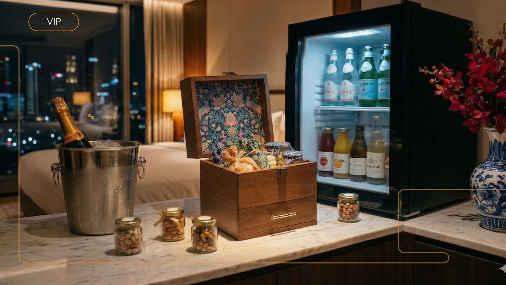 VIP suite minibar with a patterned-lined wooden chest, cashew jars, champagne on ice, and a stocked fridge